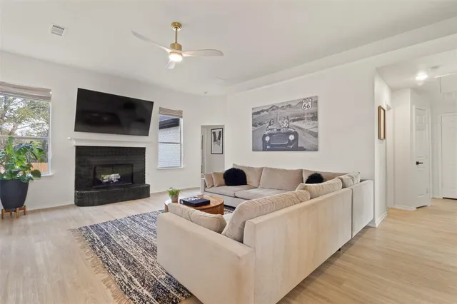 a living room with furniture a flat screen tv and a fireplace