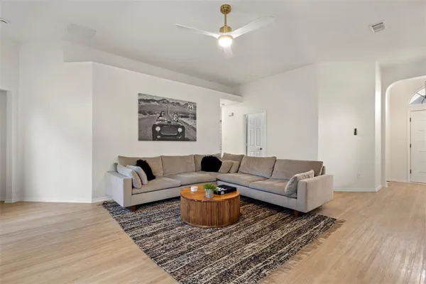 a living room with furniture a rug and a ceiling fan