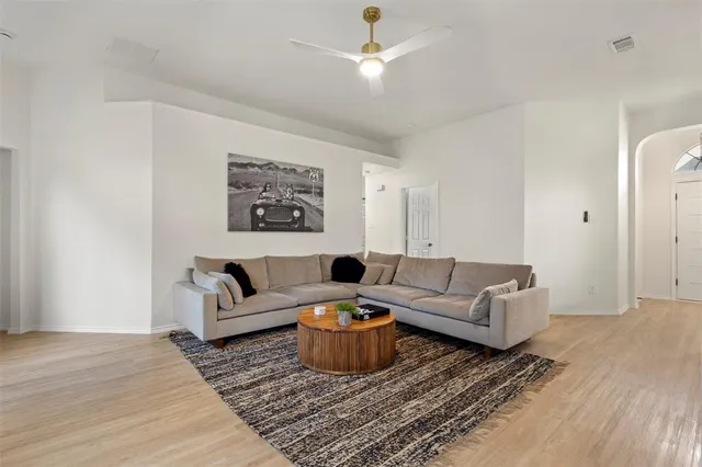 a living room with furniture a rug and a ceiling fan