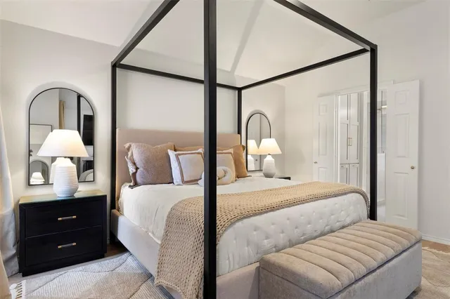 a bedroom with a bed and a dresser with mirror
