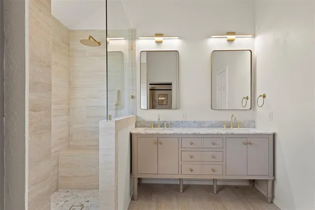 a bathroom with double vanity and a mirror