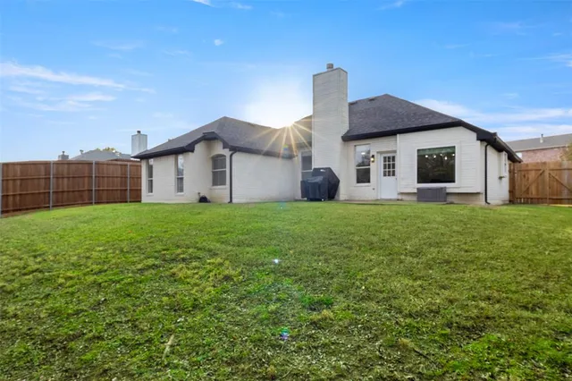a view of a house with a big yard and large trees