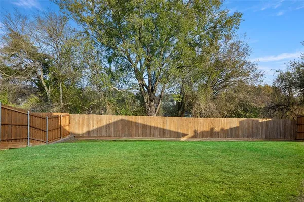 a view of yard with swimming pool and wooden fence
