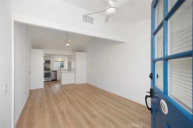 a view of a kitchen with wooden floor and a window