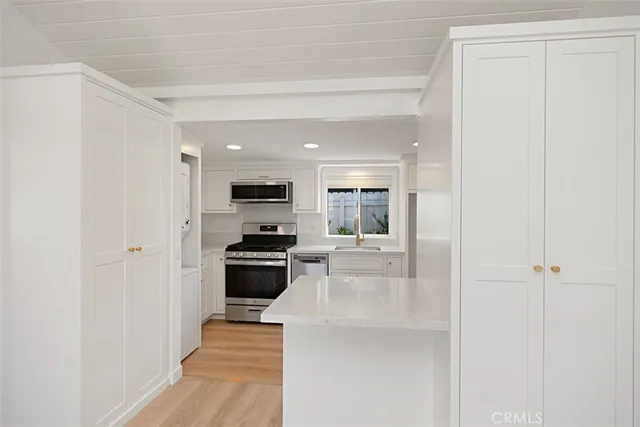 a kitchen with stainless steel appliances a refrigerator a stove top oven a sink and dishwasher