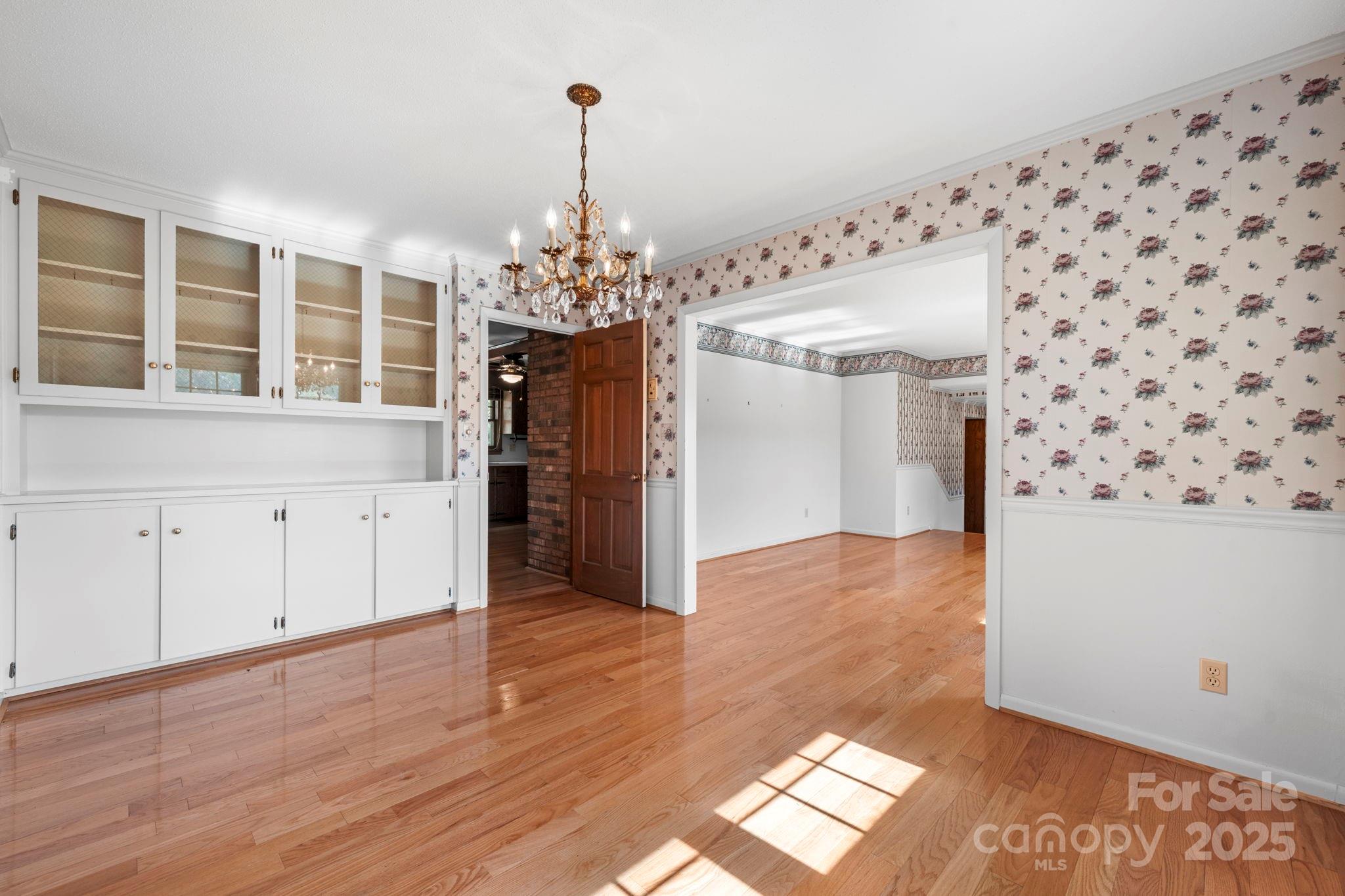 2551 Buffalo Shoals Road Newton, NC 28658 - Photo 10 of 47 a view of a hallway with wooden floor and chandelier