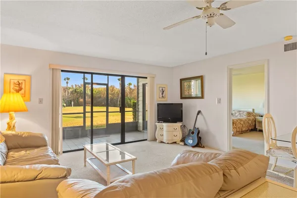 a living room with furniture two large windows and a flat screen tv