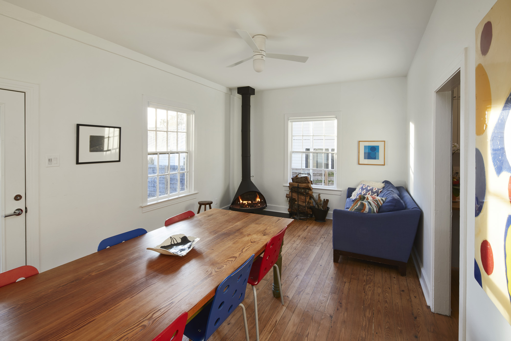 902 West Mary Street, Unit 1 Austin, TX 78704 - Photo 2 of 16 Dining area featuring a wood stove, dark wood-style flooring, healthy amount of natural light, and a ceiling fan