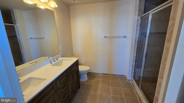 a bathroom with a granite countertop sink a toilet and shower