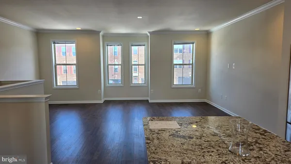 a kitchen with stainless steel appliances granite countertop a refrigerator a sink dishwasher a stove and white countertops with wooden floor