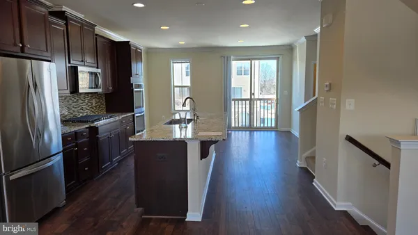 a view of kitchen with cabinets microwave and stove