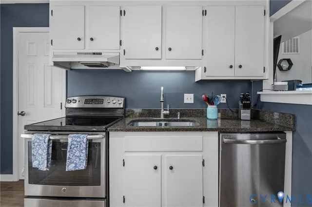 a kitchen with stainless steel appliances granite countertop a sink and a stove