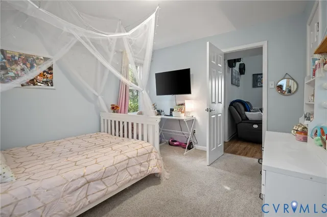a bedroom with a bed and a flat tv screen on the dresser