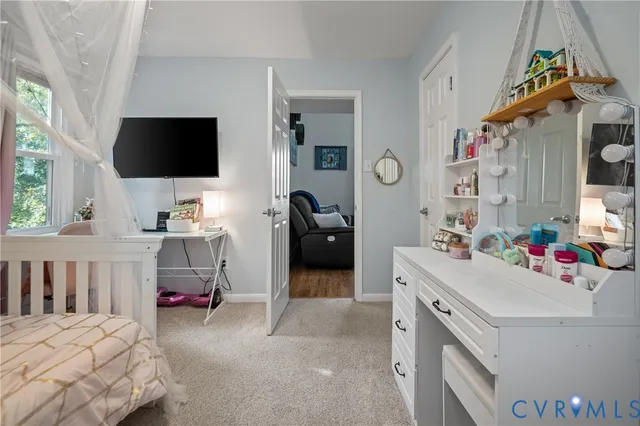 a bedroom with a bed and a flat tv screen on dresser