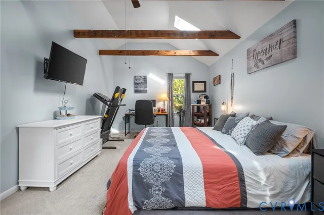 a bedroom with a bed and a flat tv screen on dresser