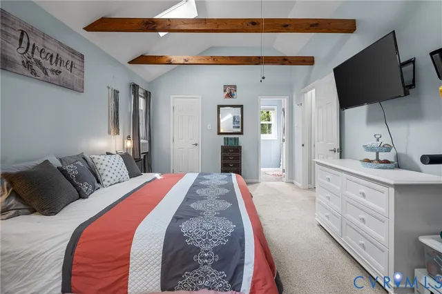 a spacious bedroom with a bed and a flat screen tv