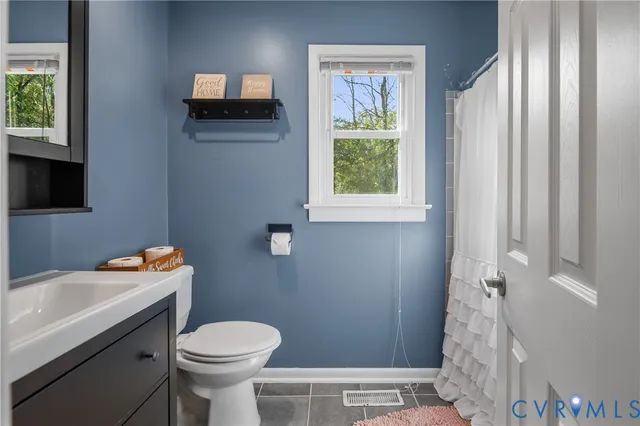 a bathroom with a sink a toilet and a window