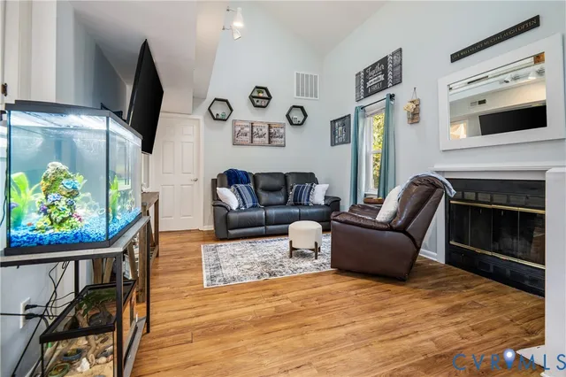 a living room with furniture a flat screen tv and a fireplace