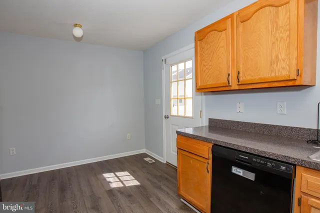 an empty room with wooden floor and window