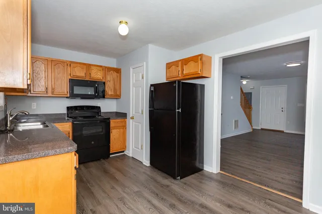 a kitchen with a refrigerator and a stove top oven