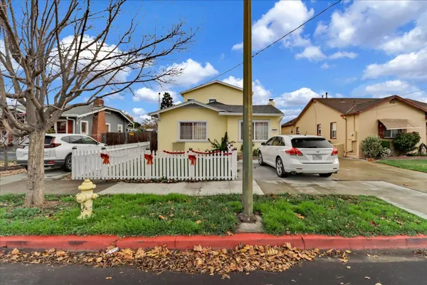 a front view of a house with a yard and potted plants