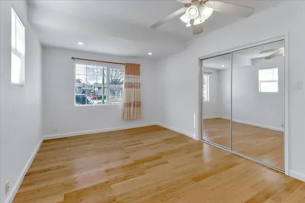 a view of empty room with wooden floor
