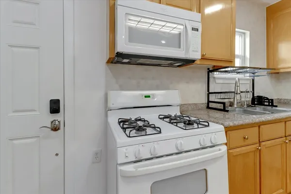 a kitchen with appliances a stove and cabinets