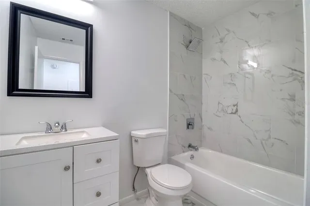a bathroom with a toilet sink vanity tub and shower
