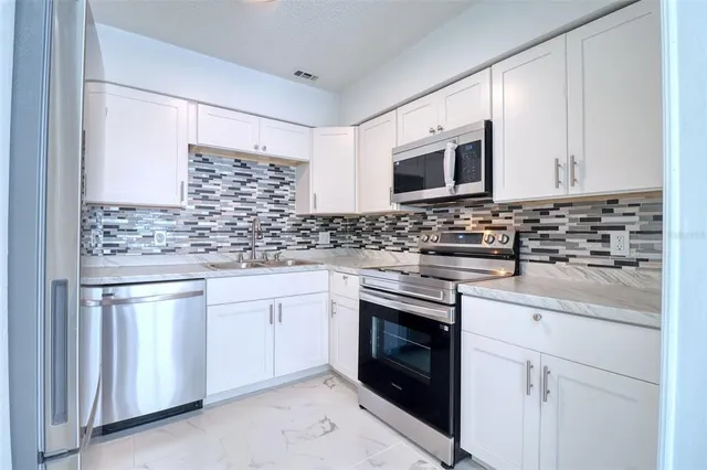 a kitchen with stainless steel appliances granite countertop a sink stove and microwave