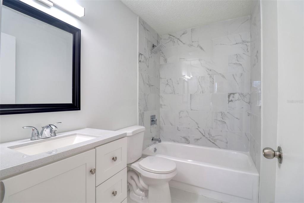 4004 Cortez Drive, Unit D Tampa, FL 33614 - Photo 10 of 30 a bathroom with a double vanity sink toilet mirror and bathtub