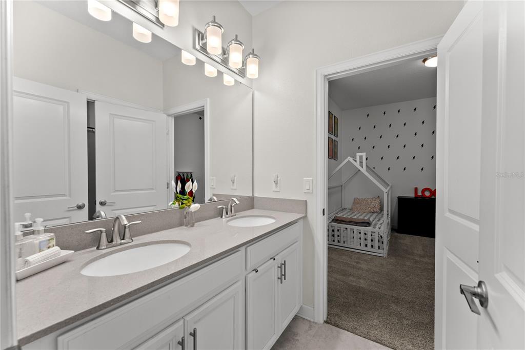 2926 Wordsmith Road Kissimmee, FL 34746 - Photo 7 of 42 a spacious bathroom with a granite countertop sink a mirror and shower