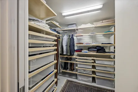 a view of walk in closet with empty racks