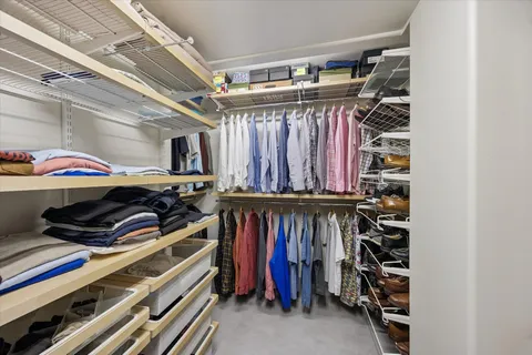 a view of walk in closet with clothes and shoes