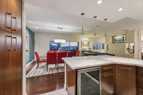 a room with stainless steel appliances kitchen island granite countertop a dining table and chairs
