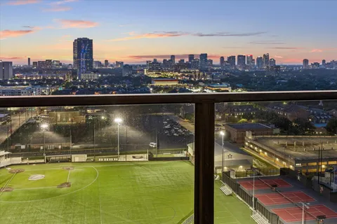 a view of a city from a balcony with seating space