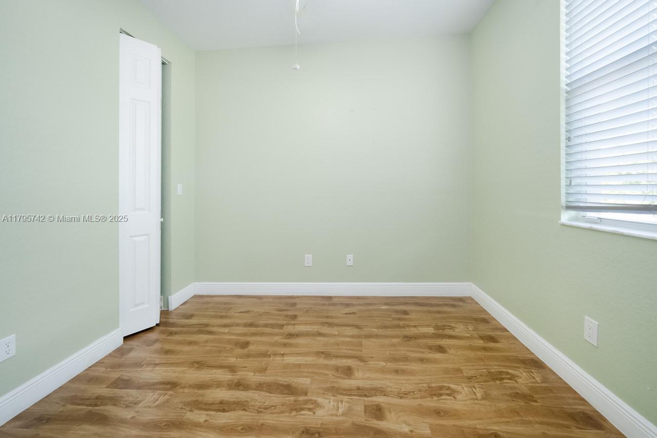 2851 Prospect Road, Unit 1208 Tamarac, FL 33309 - Photo 25 of 34 an empty room with wooden floor and windows
