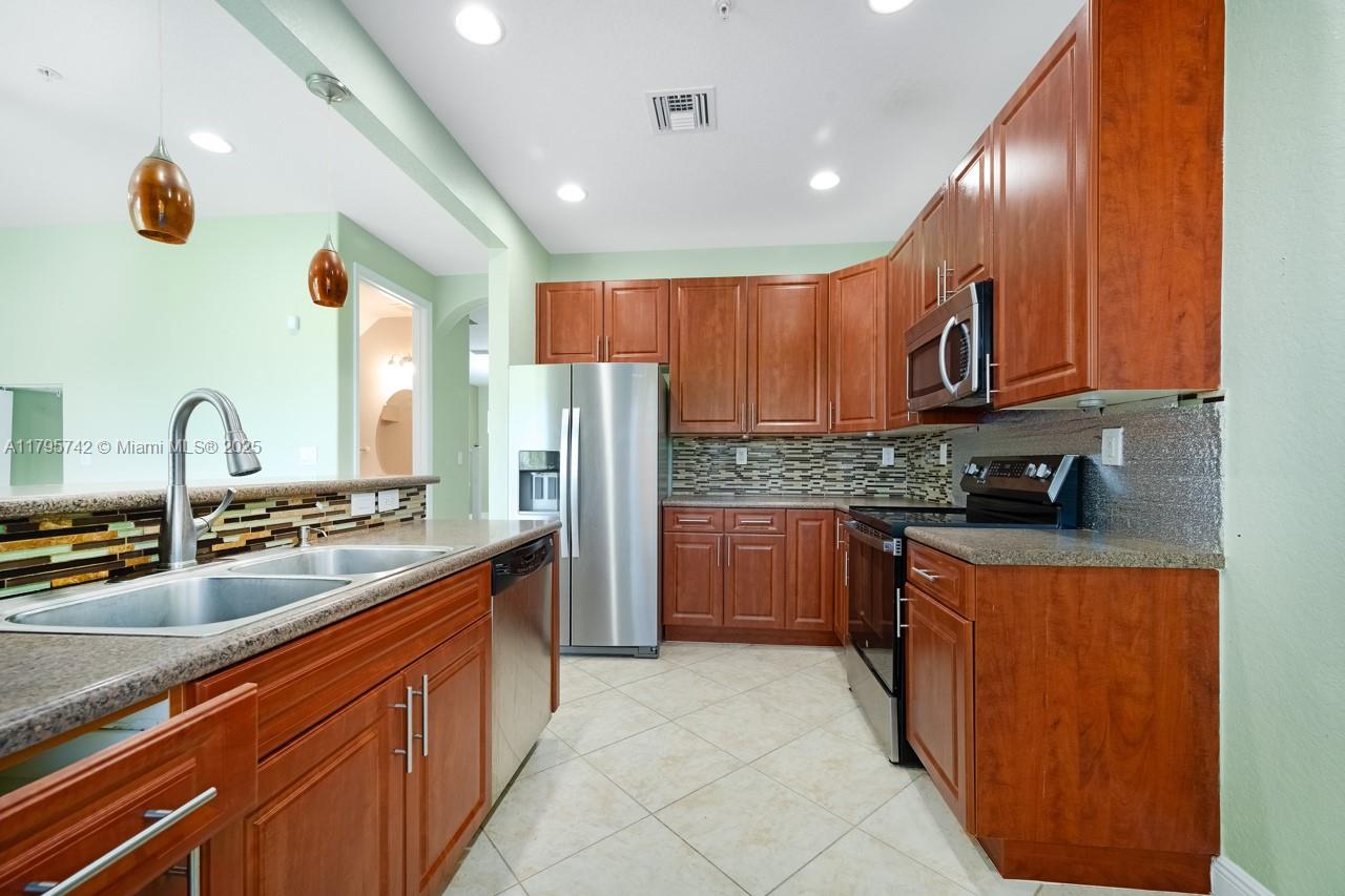 2851 Prospect Road, Unit 1208 Tamarac, FL 33309 - Photo 7 of 34 a kitchen with stainless steel appliances granite countertop a stove a sink dishwasher and a refrigerator