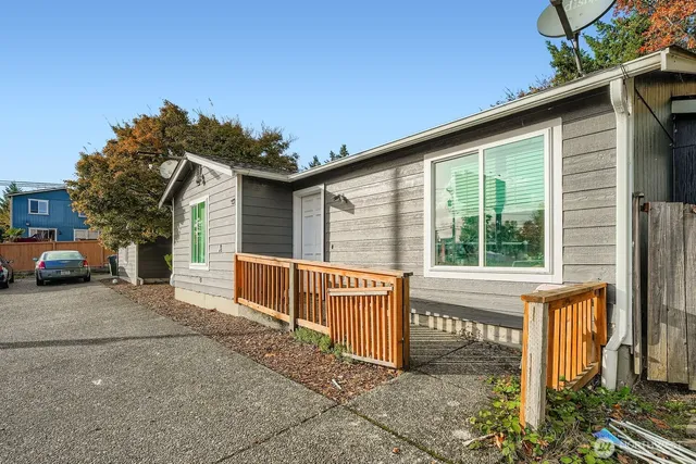 a view of a house with a large window and wooden fence