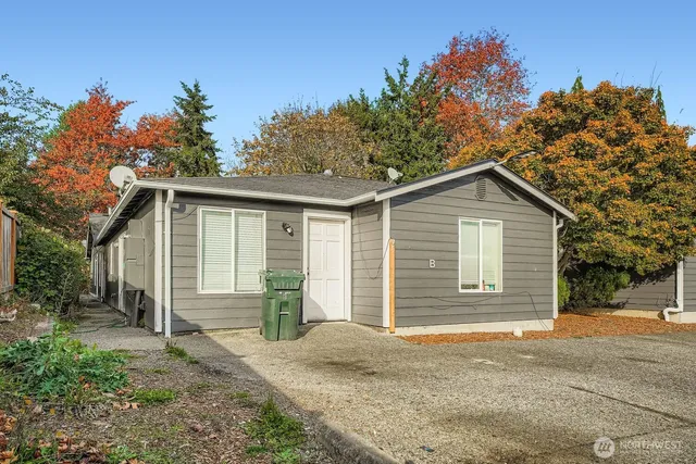 a front view of house with yard and trees in the background