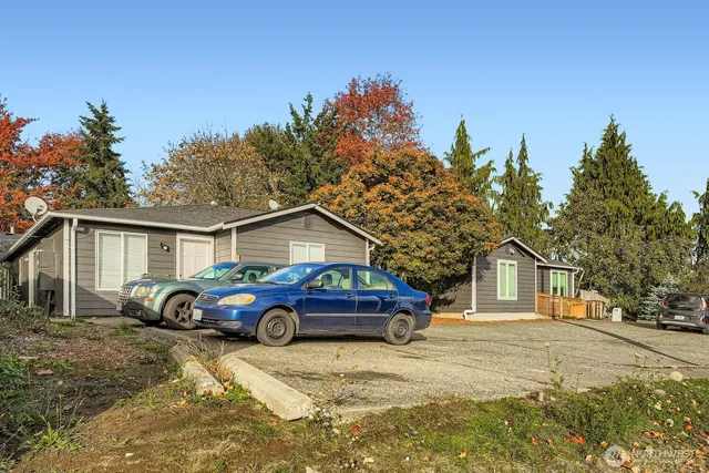 a front view of a house with cars parked