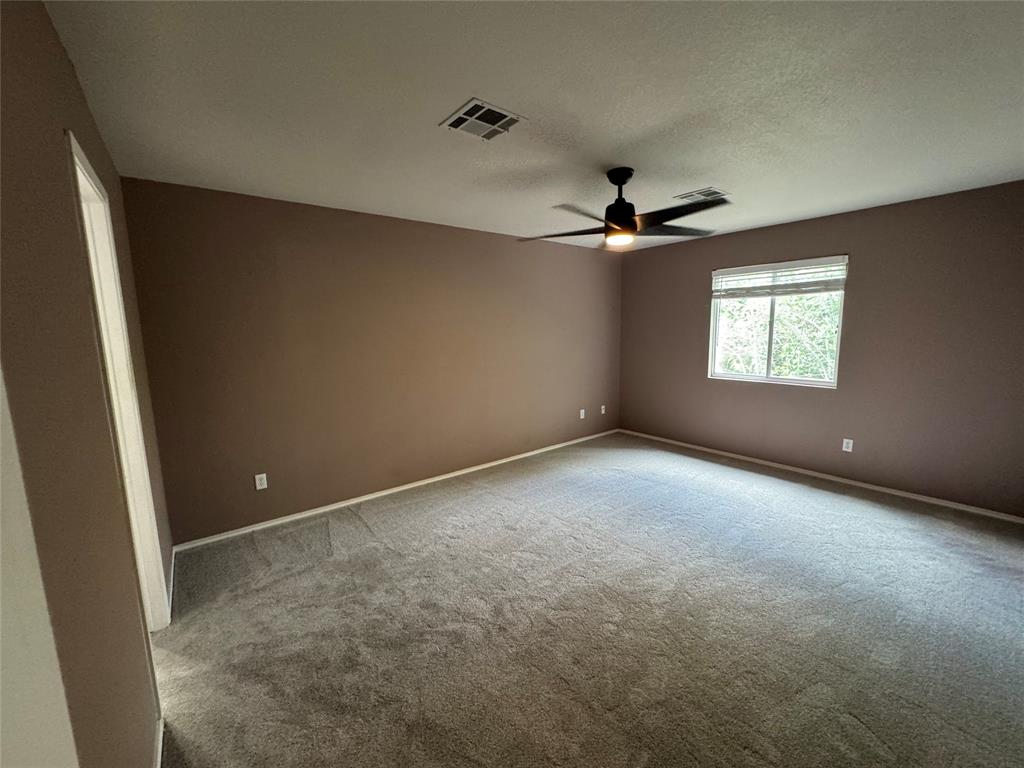 3200 Crownover Street Austin, TX 78725 - Photo 18 of 23 A spacious bedroom provides a comfortable retreat with soft carpet and natural illumination from a large window.