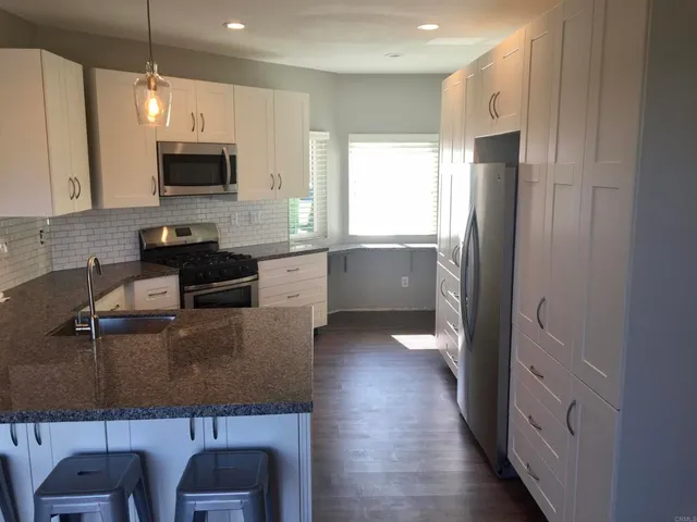 a kitchen with granite countertop a stove and a sink