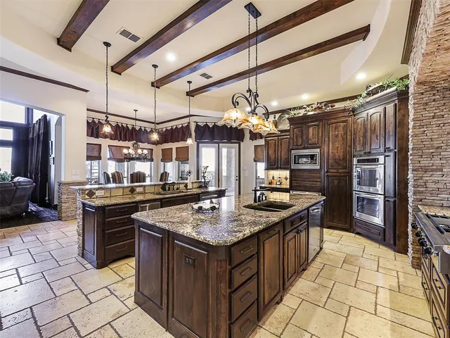 a kitchen with stainless steel appliances granite countertop a stove a sink and a refrigerator