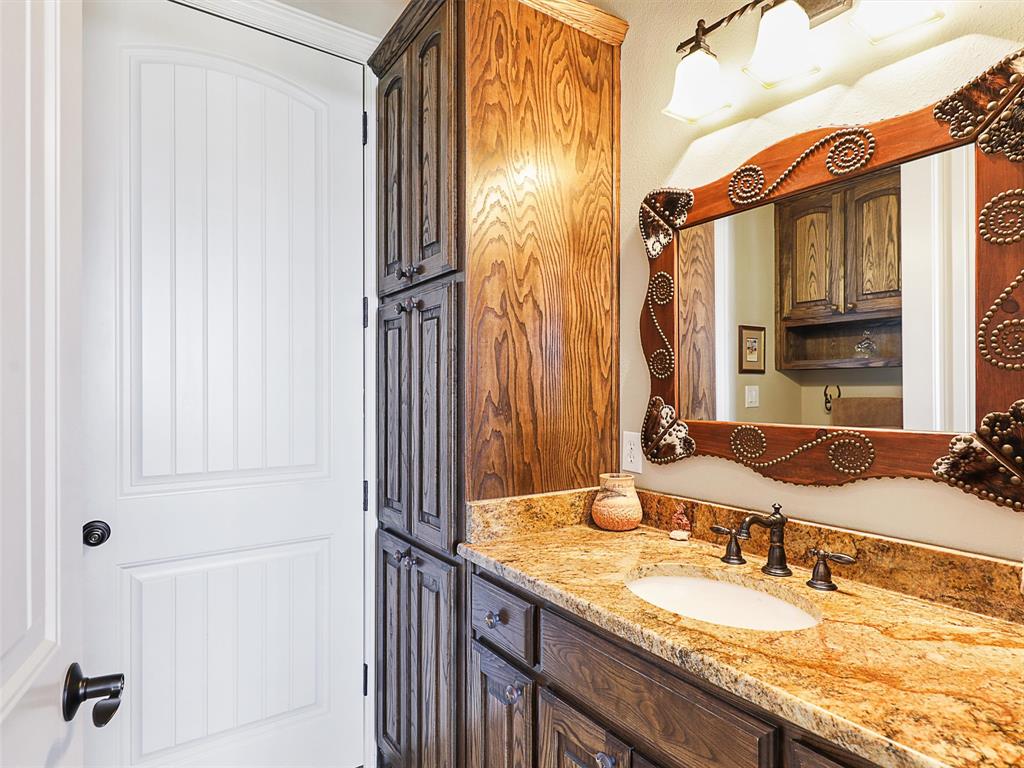 1200 McReynolds Road Sanger, TX 76266 - Photo 9 of 40 a bathroom with a granite countertop sink and a mirror