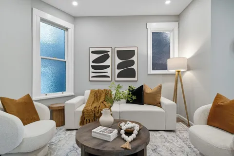 a living room with furniture kitchen and a refrigerator