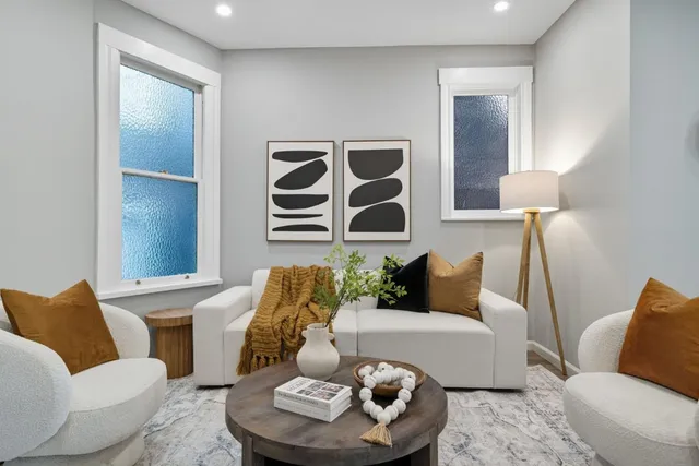 a living room with furniture kitchen and a refrigerator