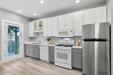 a kitchen with white cabinets and white appliances