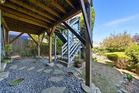 a view of backyard with plants and outdoor seating