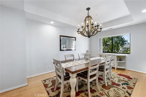 a view of a dining room with furniture a chandelier and wooden floor