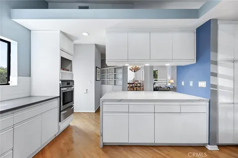 a kitchen with kitchen island granite countertop white cabinets and refrigerator